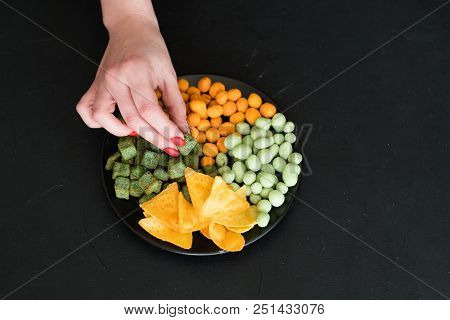 Party Snacks And Beer Munchies Concept. Chips Chili And Wasabi Peanuts And Spicy Croutons Mix On A P