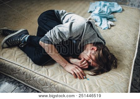 Male drug addict sleeping in bed after dose