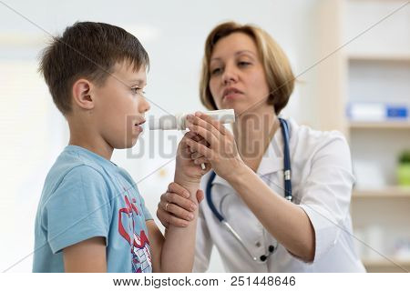 Little Boy Blowing To Peak Metr Medical Device. Doctor Examining Child's Lungs