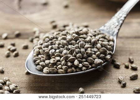 Hemp Seeds In A Metal Spoon On A Wooden Background, Close-up
