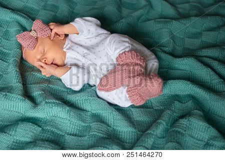 Sleeping Newborn Baby Girl In Winter Clothes. Green Woolean Cloth.