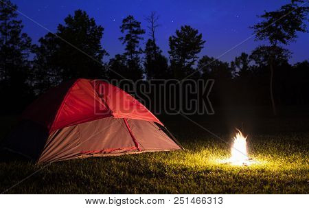 Small Campfire Lighting Up A Nylon Tent With Stars Above