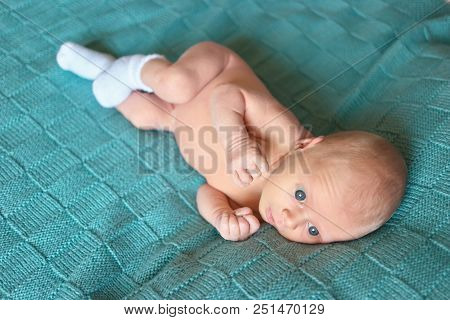 Naked Newborn Baby. Cute Caucasian Baby With Big Blue Eyes Lying On Woolean Clothes.