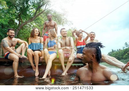 Enjoying Forest Party With Friends. Group Of Beautiful Happy Young Men And Girls Swimming At The Riv