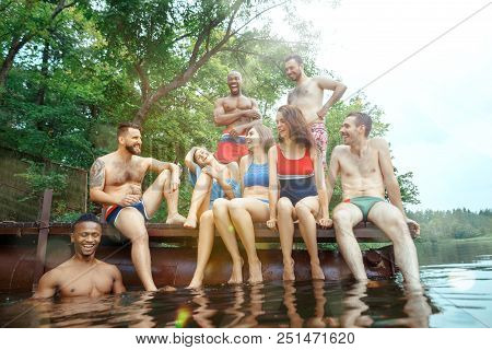 Enjoying Forest Party With Friends. Group Of Beautiful Happy Young Men And Girls Swimming At The Riv