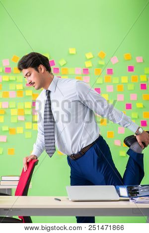 Man in the office with many conflicting priorities doing exercis