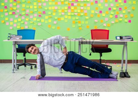 Man in the office with many conflicting priorities doing exercis