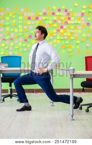 Man in the office with many conflicting priorities doing exercis