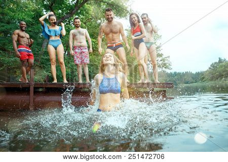 Enjoying Forest Party With Friends. Group Of Beautiful Happy Young Men And Girls Swimming At The Riv