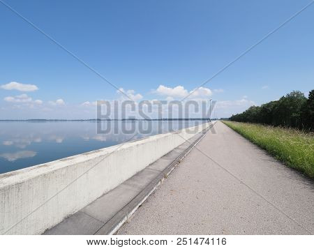 Promenade With Lamps On Barrage At Countryside Landscapes Of Lake, Grassy Field, Forest On European 