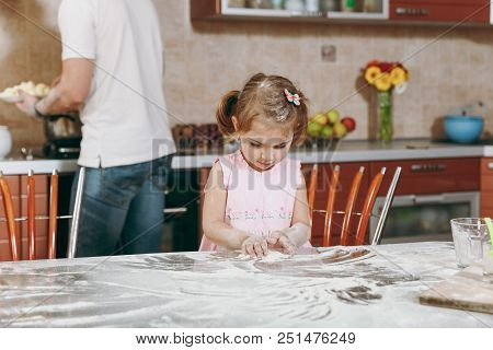 Little Kid Girl Play With Flour While Daddy Cooking In Kitchen At Table. Happy Family Dad, Child Dau