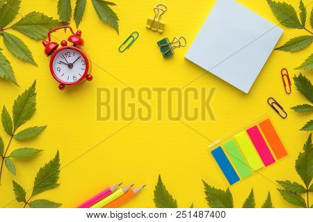 Business Concept. Notepad Alarm Clock On Yellow Background With