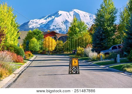 Slow children at play street sign at residential neighborhood in Colorado at autumn, USA. Mount Sopris landscape.