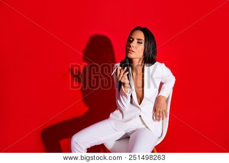Portrait Of Pleased Delightful Woman Enjoying Smoking Cigarette Wearing White Suit With Tempting Dec