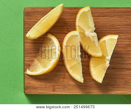 Top view natural citrus fruit - slices of lemon on a wooden board - ingredient for preparing summer homemade cocktail. Concept of healthy diet food and drinks.