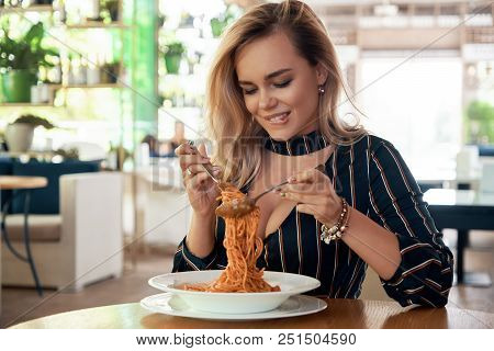 Sensual Woman Rolling Spaghetti And Keeping On A Fork To Eat. Beautiful Girl Blonde Hair And Make-up