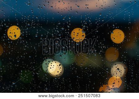 Rain On Glass Background. Street Bokeh Lights Out Of Focus.