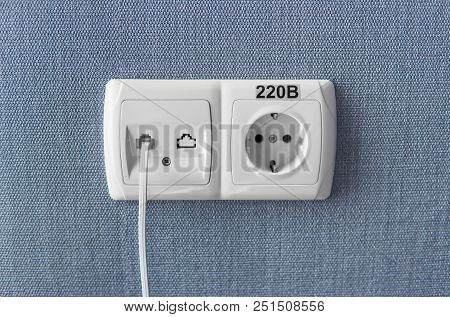 Socket On A Blue Wall, A Multifunction Outlet With An Internet Connection And European-style Outlet