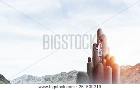 Young Female Doctor With Folder In Hands Satnding On Stone Column