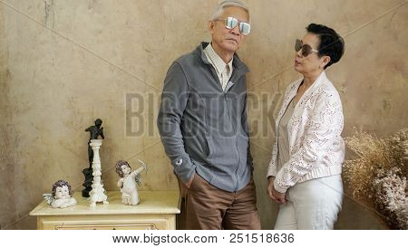 Happy Asian Senior Couple Casual Dress With Sunglasses In Vintage House
