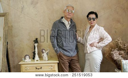 Happy Asian Senior Couple Casual Dress With Sunglasses In Vintage House
