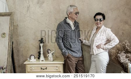 Happy Asian Senior Couple Casual Dress With Sunglasses In Vintage House
