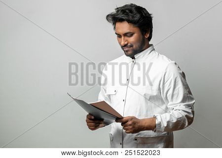 Young Doctor Looking At The Resalts Of Tests. Cheerful Student Reading Report At The Medical Univers