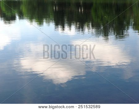 Reflection Of Trees And Clouds In Water