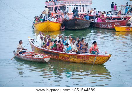 VARANASI, UTTAR PRADESH, INDIA - JULY 6, 2018: Boats with pilgrims arriving at ceremonies Dasashvamedh Ghat 