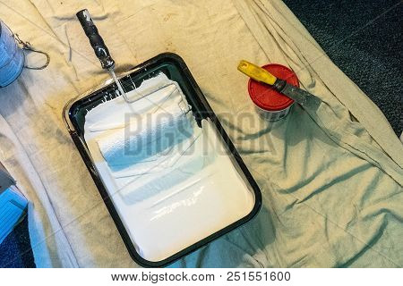 Paint And Roller In A Pan With Spackling And Puddy Knife.