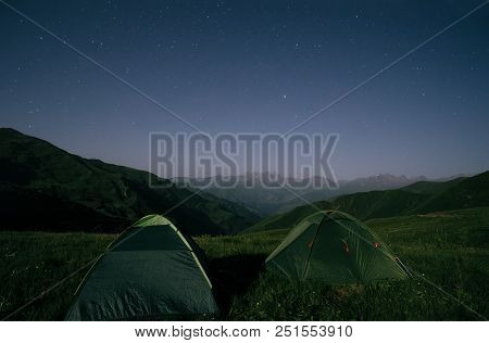 Night Landscape Of Two Camping Tents And A Mountain Range At The Background. Chaukhi Mountain Range 