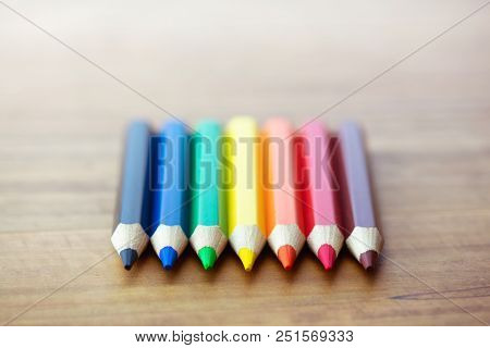 Tips of fat and short Colored pencils on a wooden desk.Shallow depth of field for dreamy impressional feel.