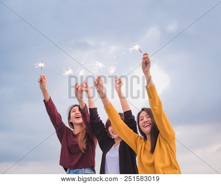Happy Group Of Asian Girl Friends Enjoy And Play Sparkler At Roof Top Party At Evening Sunset,holida