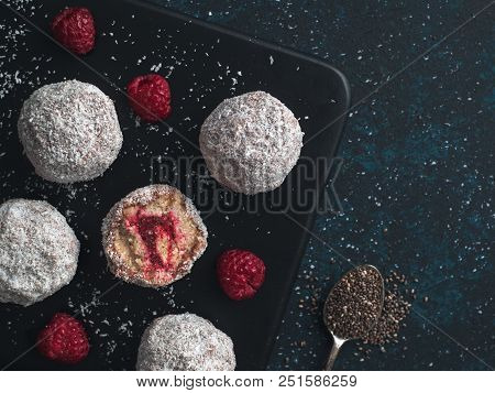 Raw Vegan Lamington Bliss Balls With Raspberries Chia Jam On Dark Background. No Baked Healthy Vegan