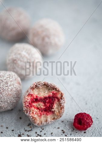 Raw Vegan Lamington Bliss Balls With Raspberries Chia Jam On Gray Background. No Baked Healthy Vegan