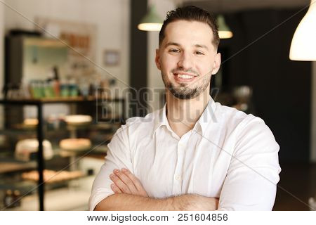 Young Male Smiling Administrator Standing With At Cafe. Concept Of Business And Success.