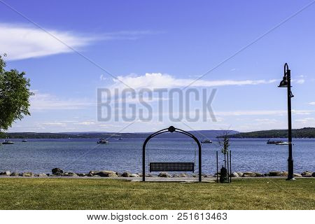 Swing On The Lakeshore Of Canandaigua Lake. Finger Lakes Of New York. View Of Boats On The Calm Lake