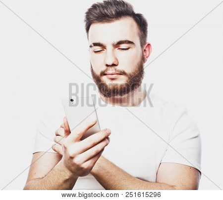 Tehnology and people concept: Bearded man  typing sms on white  background
