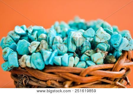 Pile Stones Of Raw Turquoise In Small Wooden Nest On A Brown Background. Blue And Green Color Stones