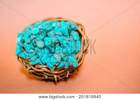 Pile Stones Of Raw Turquoise In Small Wooden Nest On A Brown Background. Blue And Green Color Stones