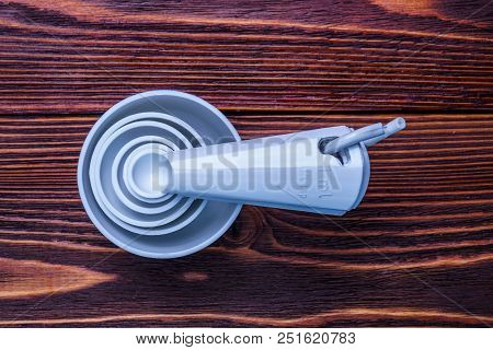 Measuring Set Table Spoons And Cups Plastic White Color On A Wooden Background. Devices, Measuring I