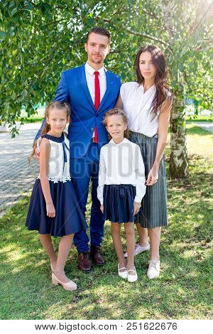 Young Parents Brought Their Kids To School On The First Of September. First Class And Third Class. A