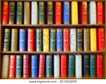 Blured Of Colorful Books, Textbook, Literature On Wood Bookshelf In Library. Background.