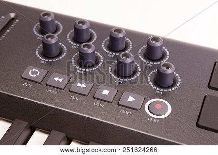 Close-up Of A Row Of Knobs On A Midi Controller Keyboard On White Background