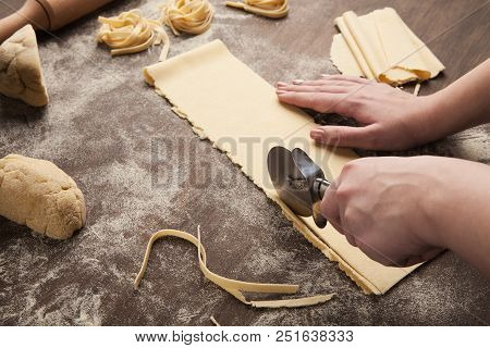 Cutting Raw Dough. Chef Using Wheel Cutter In Preparation Of Italian Pasta On Kitchen Table, Copy Sp