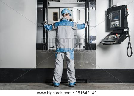 Large Cnc Machine Operator. Caucasian Metalworking Worker In Front Of The Machine.
