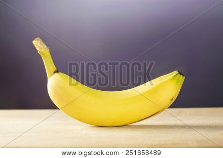 One Whole Fresh Yellow Banana With Grey Gradient Behind