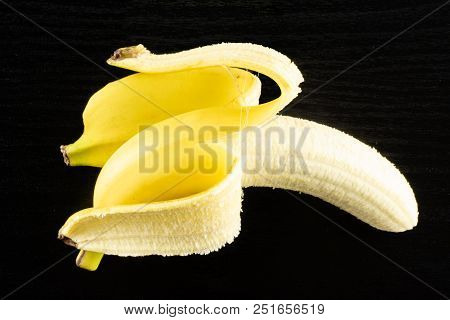 One Whole Opened Fresh Yellow Banana Flatlay On Black Wood