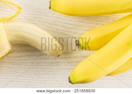 Lot Of Whole Fresh Yellow Banana And One Opened Flatlay On Grey Wood