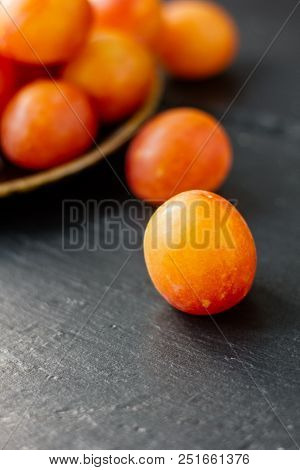 Whild Ripe Plums On Black Stone Surface.